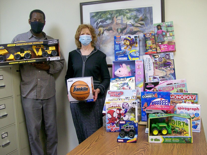 United Way Chief  Professional Officer Julian Dawson and Treasurer Linda Barriger from the Monticello Kiwanis display donated games and toys.